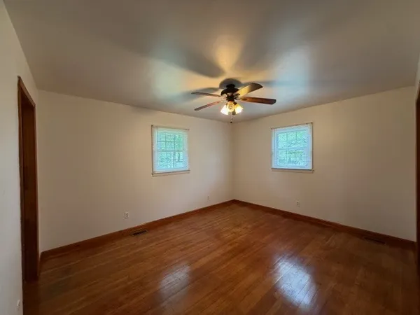 a view of an empty room with a chandelier fan