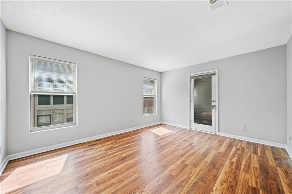 717 Beaufort Circle Duluth, GA 30096 - Photo 13 of 42 a view of an empty room with wooden floor and a window