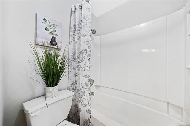 a bathroom with a toilet a sink and shower