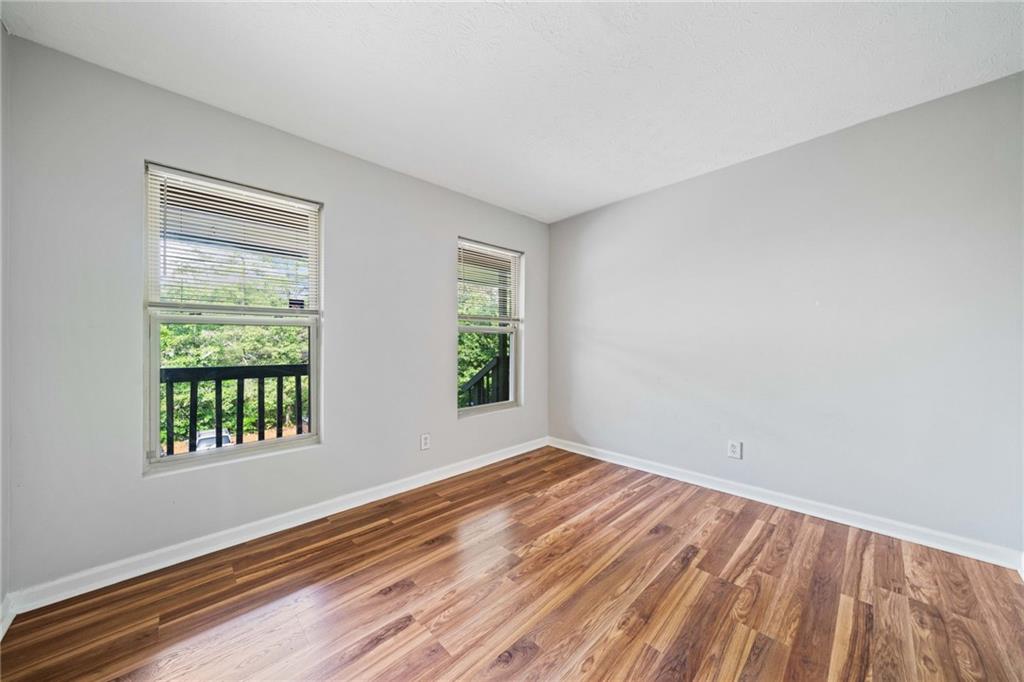 717 Beaufort Circle Duluth, GA 30096 - Photo 19 of 42 a view of an empty room with wooden floor and a window