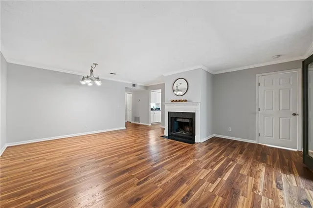 a view of empty room with wooden floor and fireplace