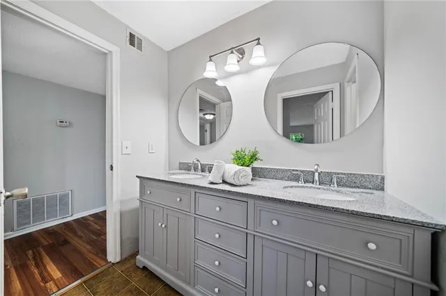 a bathroom with a double vanity sink and a mirror