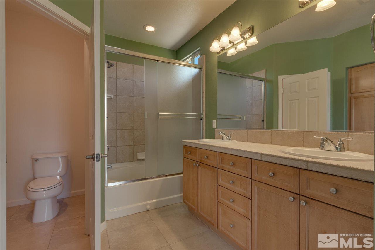 1721 Camaraderie Way Reno, NV 89521 - Photo 15 of 18 a bathroom with a double vanity sink toilet and shower