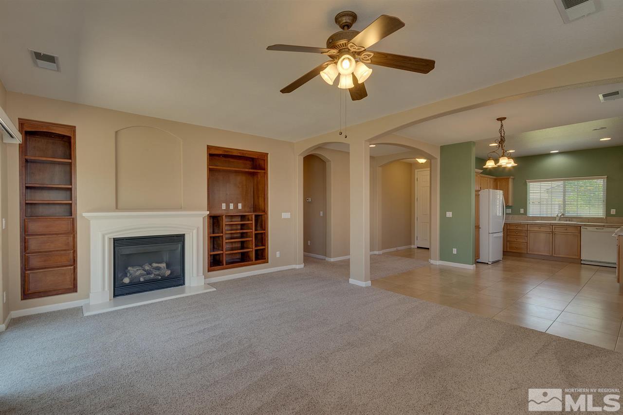 1721 Camaraderie Way Reno, NV 89521 - Photo 7 of 18 a view of a livingroom with a fireplace a ceiling fan and windows