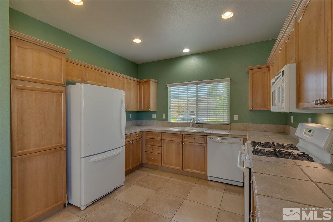 1721 Camaraderie Way Reno, NV 89521 - Photo 9 of 18 a kitchen with stainless steel appliances granite countertop a refrigerator and a stove top oven