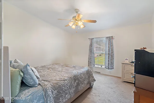 a bedroom with a bed and ceiling fan