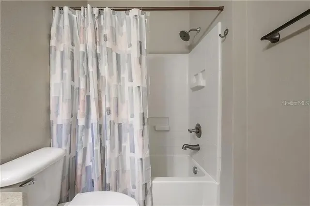 a bathroom with a shower curtain and a toilet