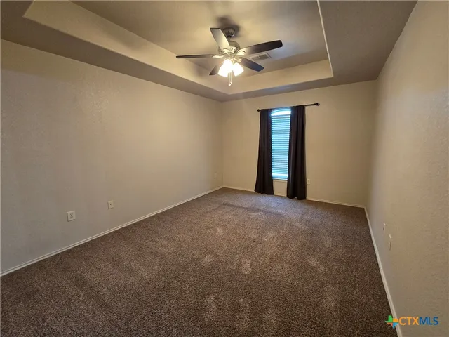 a view of an empty room with a ceiling fan