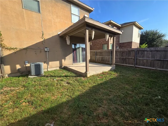 a backyard of a house with table and chairs