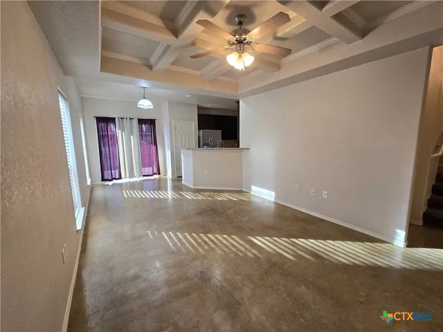 en empty room with windows and ceiling fan
