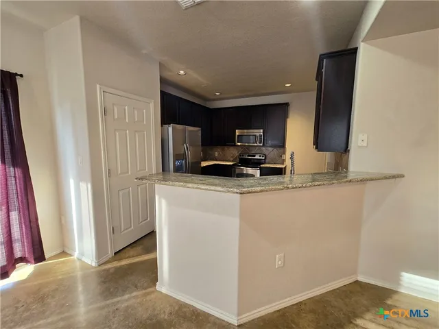 a view of kitchen and refrigerator