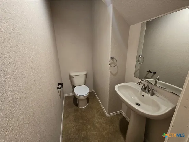 a bathroom with a sink a toilet and mirror