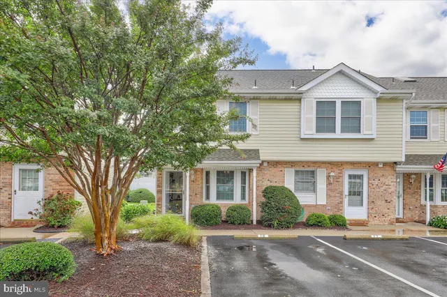 a front view of a house with garden and parking