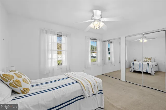 a spacious bedroom with a bed and ceiling fan