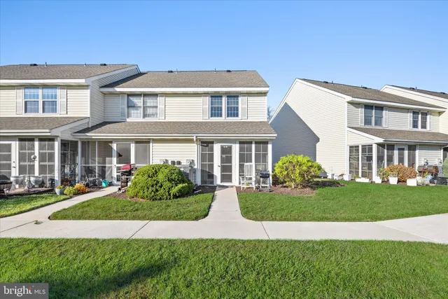 a front view of a residential houses with yard and green space