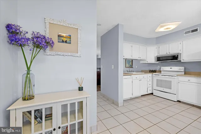 a kitchen with white cabinets and white appliances
