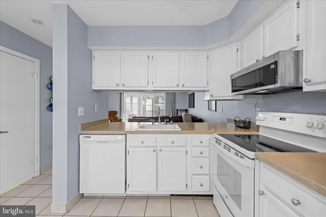 a kitchen with white cabinets and white appliances