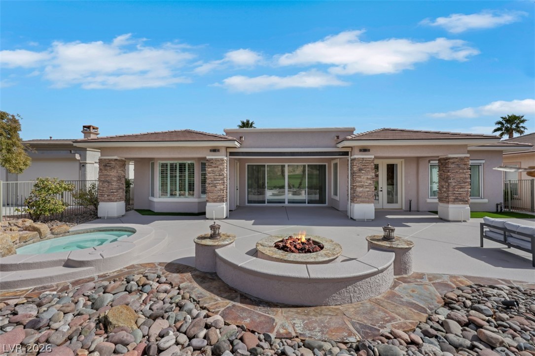 5015 Rivedro Street Las Vegas, NV 89135 - Photo 59 of 91 An inviting backyard oasis offers a built-in spa, fire pit, and ample patio space for outdoor enjoyment.