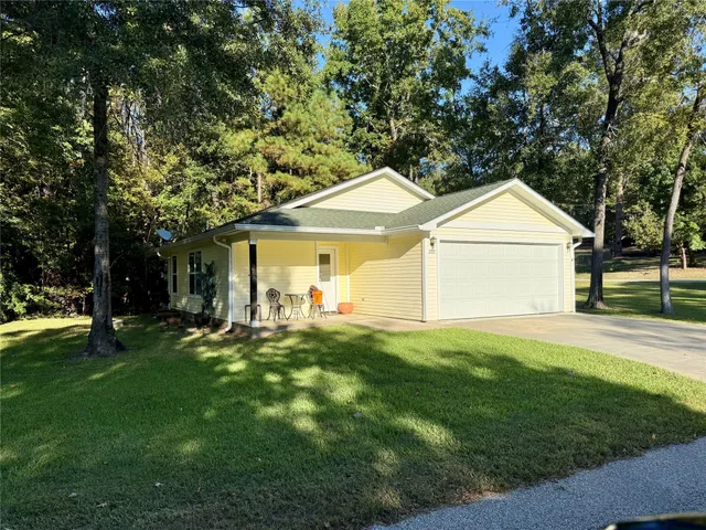 a front view of a house with a yard and trees