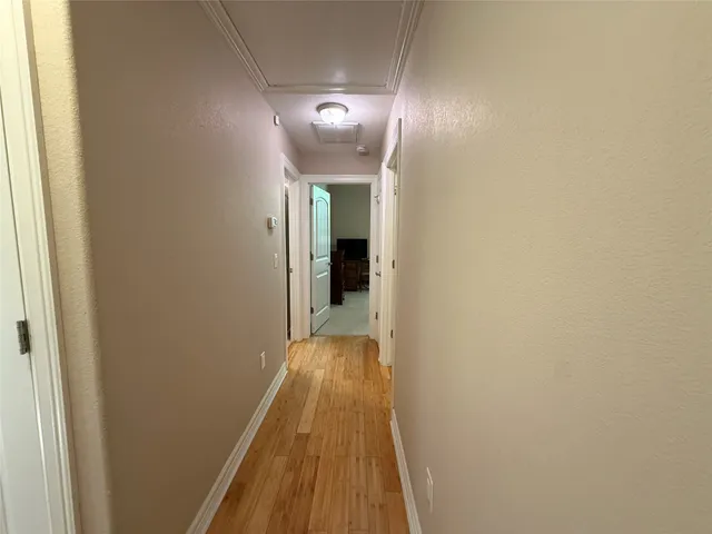 a view of a hallway with wooden floor