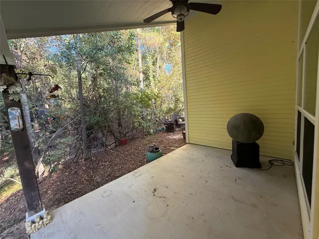 a view of a porch with a floor to ceiling window and tree