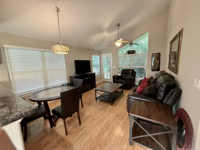 a living room with furniture a flat screen tv and a floor to ceiling window