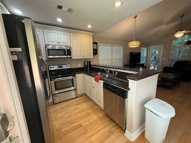 a kitchen with stainless steel appliances a stove a sink and a refrigerator