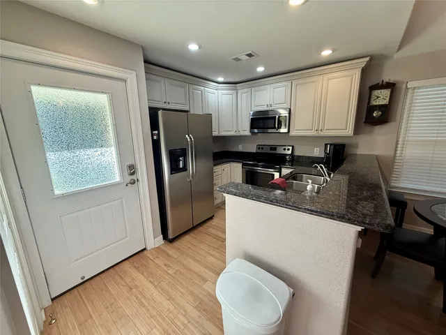 a kitchen with stainless steel appliances granite countertop a refrigerator sink and microwave