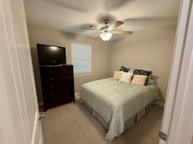 a bedroom with a bed and a flat tv screen on dresser