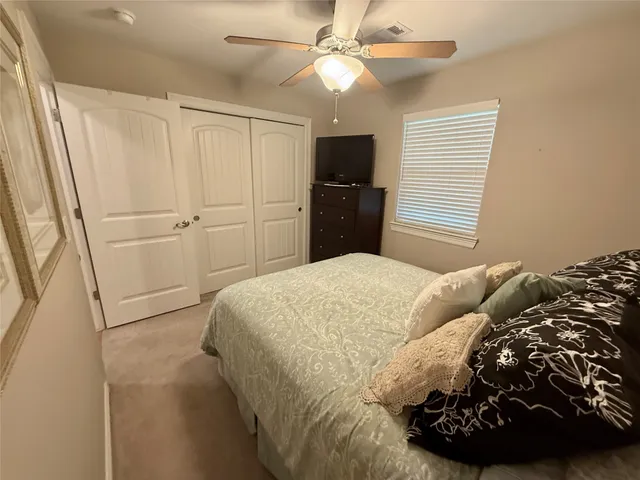 a bedroom with a bed and a ceiling fan