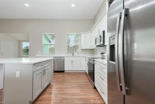 a kitchen with white cabinets and white appliances