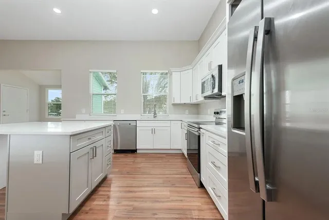 a kitchen with white cabinets and white appliances