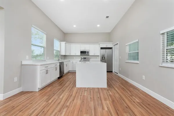 a kitchen with wooden floors and white appliances