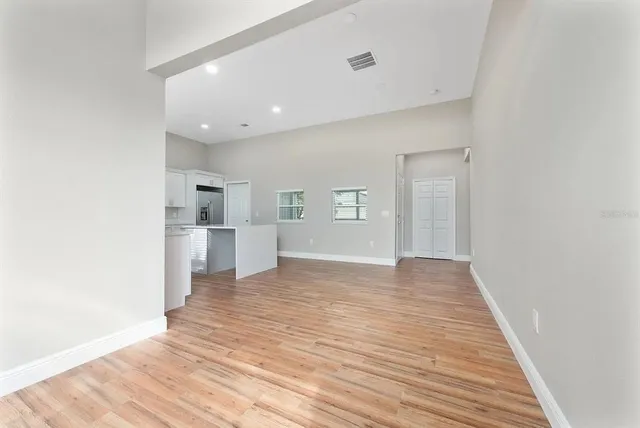 a view of a kitchen with wooden floor and a refrigerator