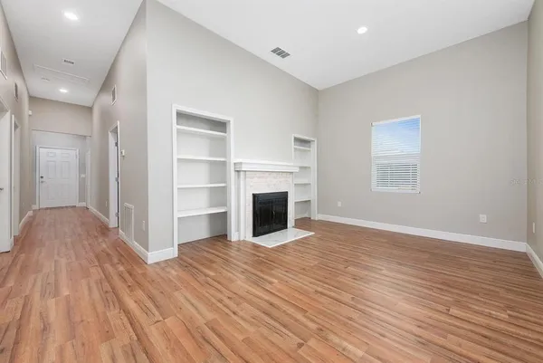 a view of a livingroom with wooden floor and a fireplace