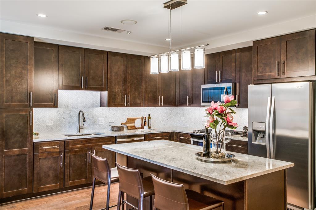 4719 Cole Avenue, Unit 358 Dallas, TX 75205 - Photo 3 of 35 a kitchen with granite countertop a table chairs stove and refrigerator