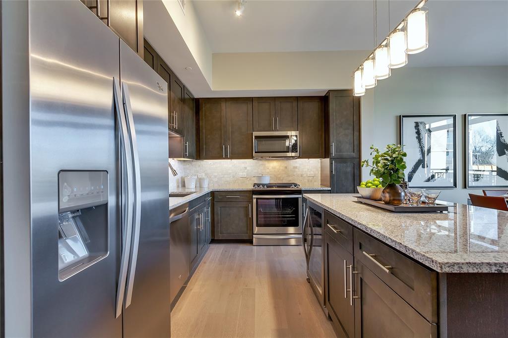4719 Cole Avenue, Unit 358 Dallas, TX 75205 - Photo 5 of 35 a kitchen with kitchen island granite countertop stainless steel appliances and sink