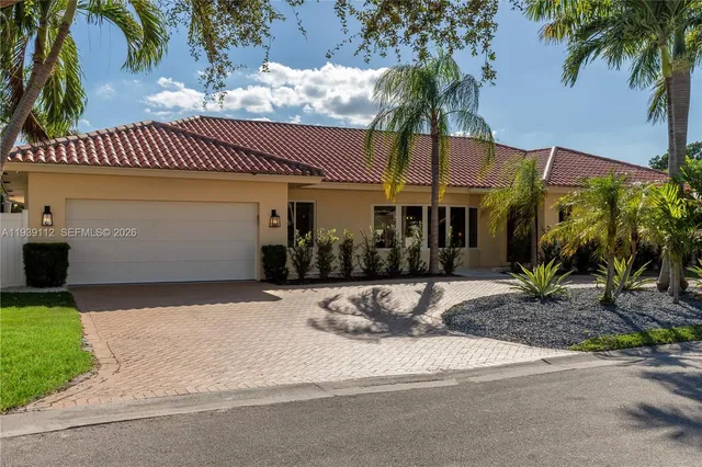 a row of palm trees in front of a house