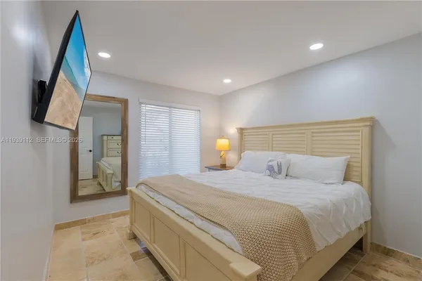 a bedroom with a large bed and a large window