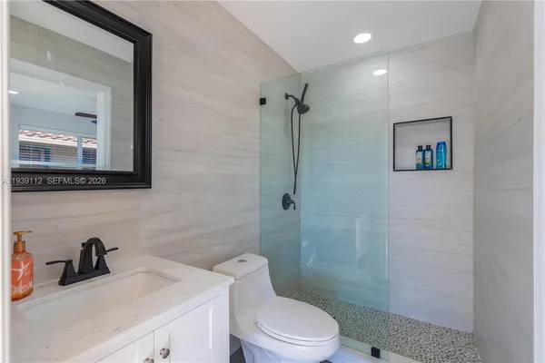 aerial view of a house with swimming pool and lawn chairs under an umbrella
