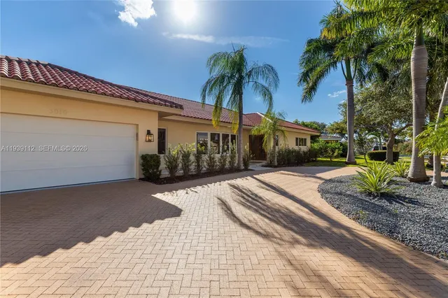 a view of a brick house with a large window and yard