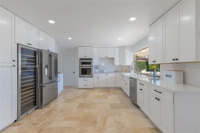 a kitchen with stainless steel appliances a refrigerator sink and stove