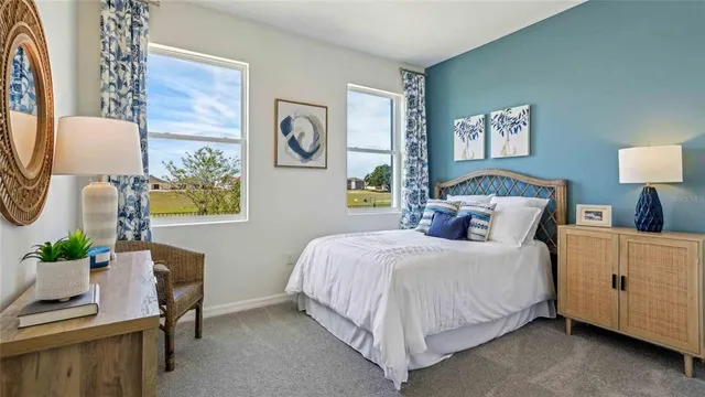 a bedroom with a bed and a lamp on dresser