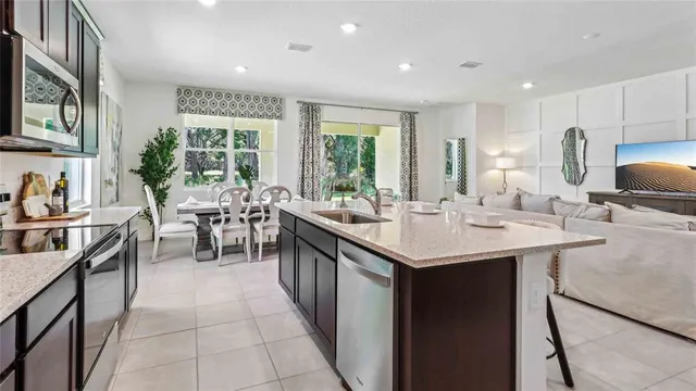 a kitchen with a sink and chairs