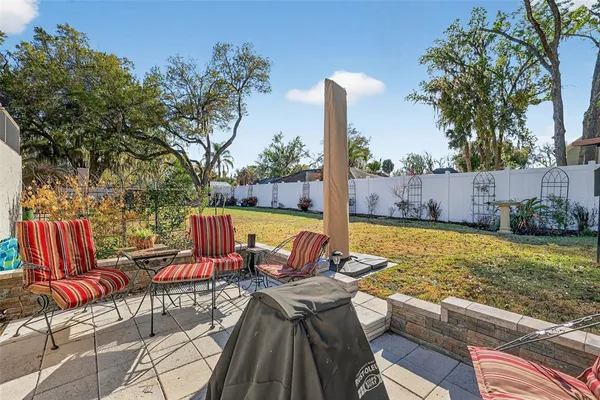 a view of a patio with a table and chairs a barbeque