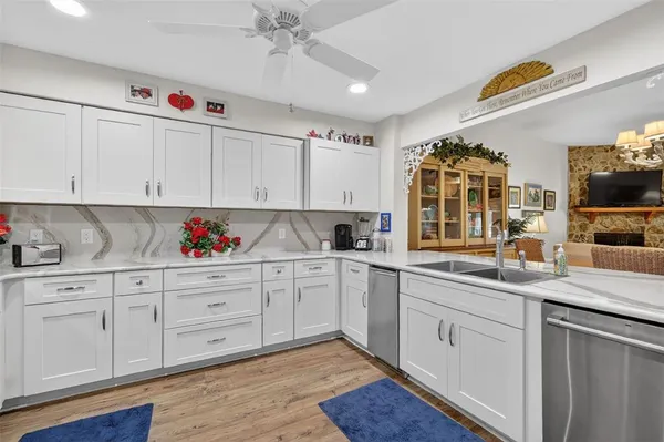 a kitchen with granite countertop white cabinets and white appliances
