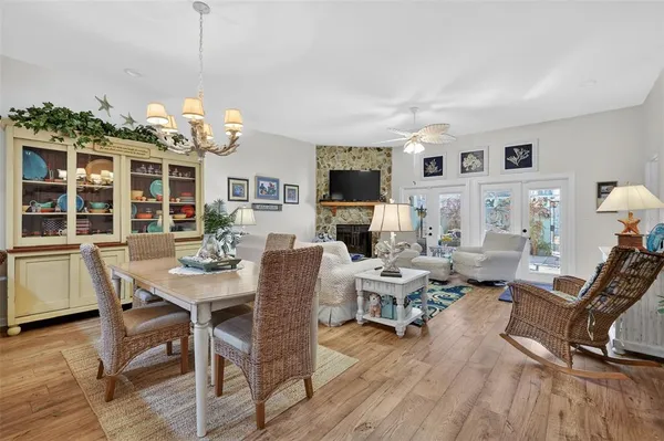 a view of a livingroom with furniture a chandelier and wooden floor