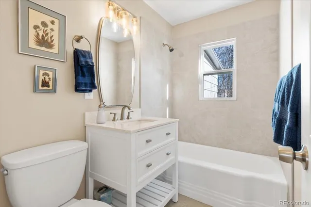 a bathroom with a granite countertop toilet a sink and a bathtub