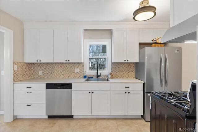 a kitchen with white cabinets and a stove