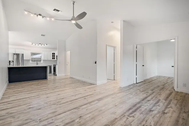 a view of a kitchen with wooden floor and a ceiling fan
